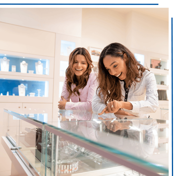 Two women looking at jewelry behind a glass counter